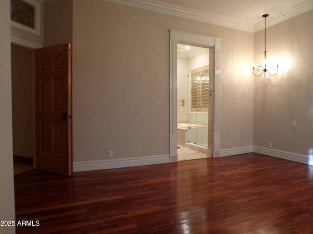 empty room with hardwood / wood-style flooring, crown molding, and a chandelier