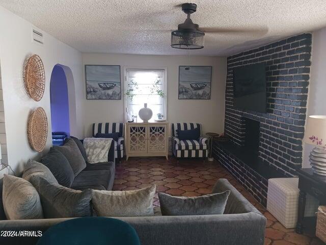 5539 N 31st Ln, Phoenix, AZ 85017 - living room with arched walkways, a textured ceiling, and a fireplace