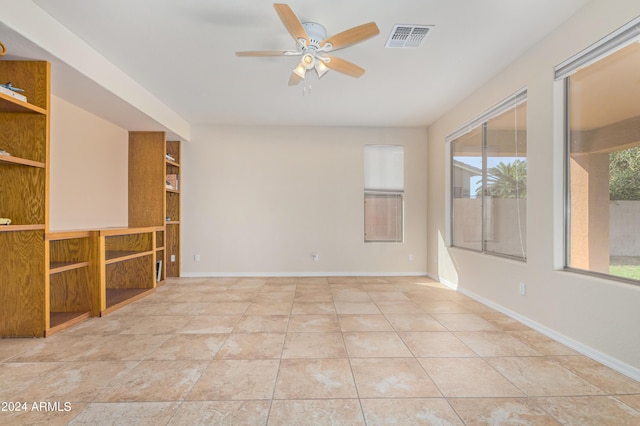 tiled spare room featuring a healthy amount of sunlight and ceiling fan