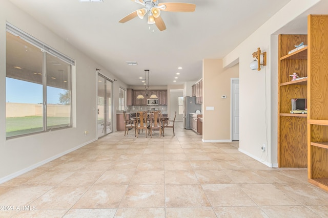 kitchen featuring pendant lighting, light tile patterned floors, ceiling fan, appliances with stainless steel finishes, and backsplash