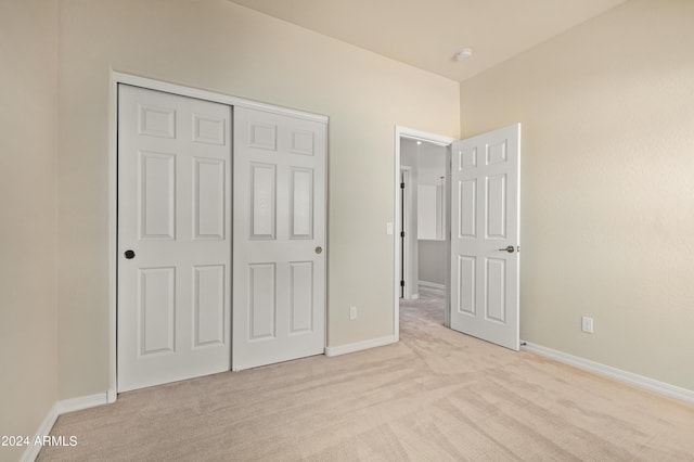 unfurnished bedroom with a closet and light carpet