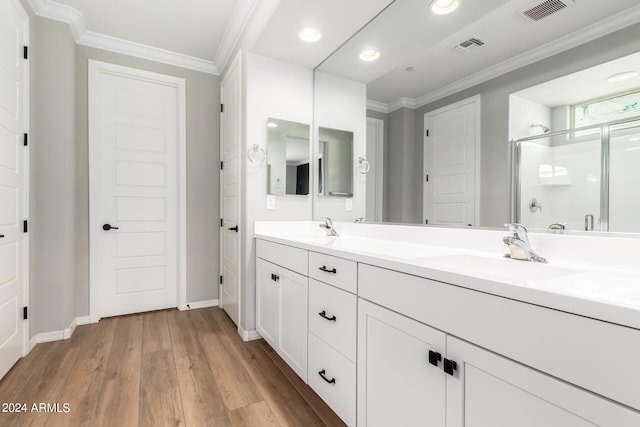 bathroom featuring ornamental molding, vanity, hardwood / wood-style floors, and an enclosed shower