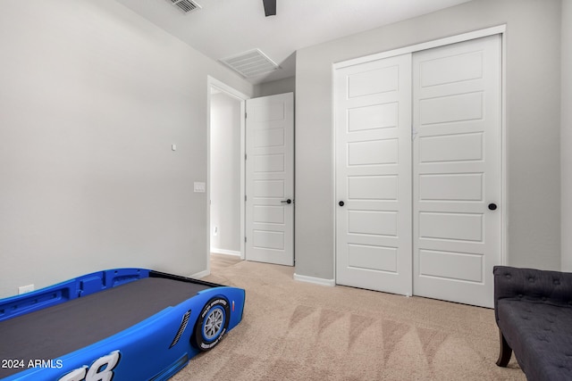 carpeted bedroom featuring ceiling fan and a closet