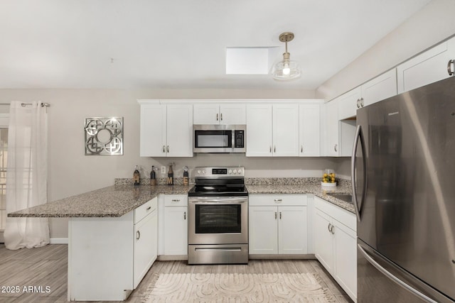 5649 W Holly St, Phoenix, AZ 85035 - kitchen with stainless steel appliances, a peninsula, white cabinetry, and light stone counters