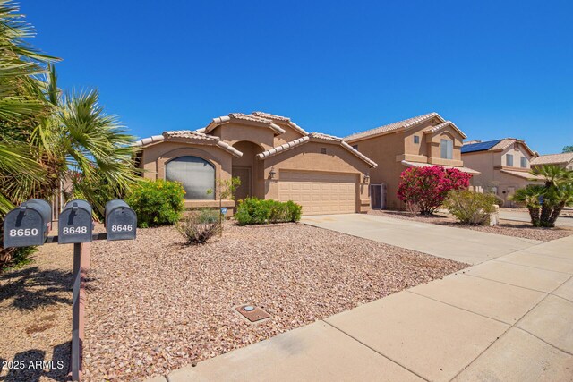 8648 W Fargo Dr, Peoria, AZ 85382 - mediterranean / spanish-style house with stucco siding, driveway, a tiled roof, and an attached garage