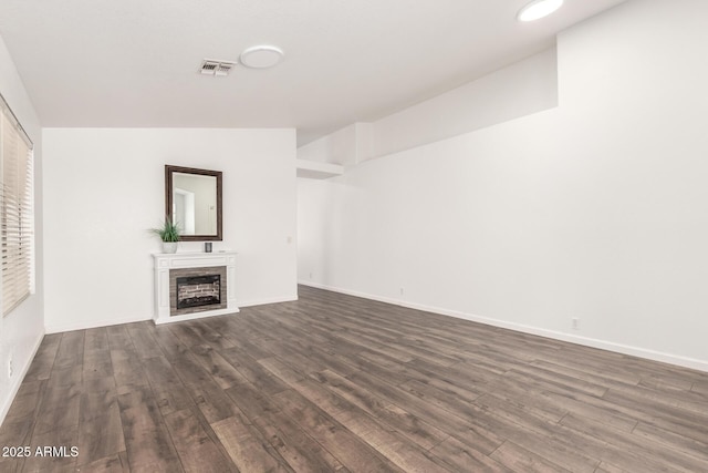 8648 W Fargo Dr, Peoria, AZ 85382 - unfurnished living room featuring visible vents, baseboards, dark wood-style floors, and a brick fireplace