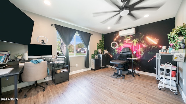 office space featuring ceiling fan, a wall mounted air conditioner, and light wood-type flooring