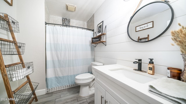 bathroom featuring walk in shower, hardwood / wood-style floors, vanity, and toilet