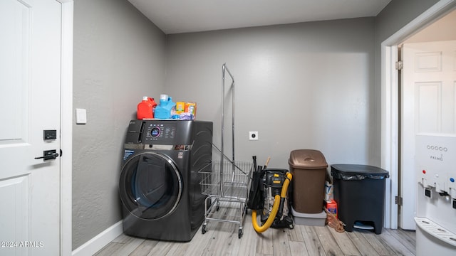 laundry area featuring washer / dryer and light hardwood / wood-style flooring