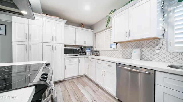 kitchen featuring backsplash, white cabinetry, light hardwood / wood-style floors, and appliances with stainless steel finishes