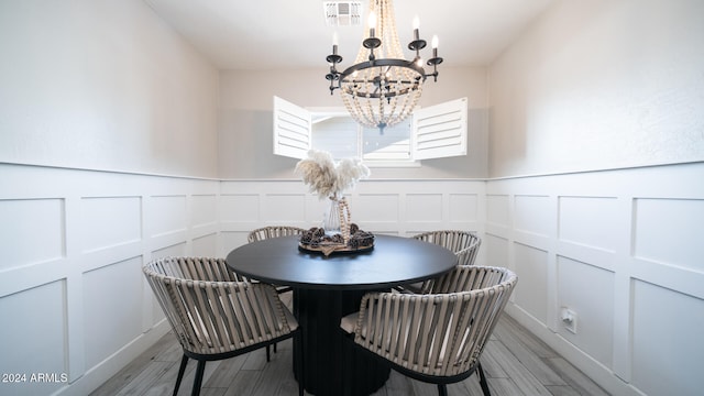 dining space with light hardwood / wood-style floors and a chandelier