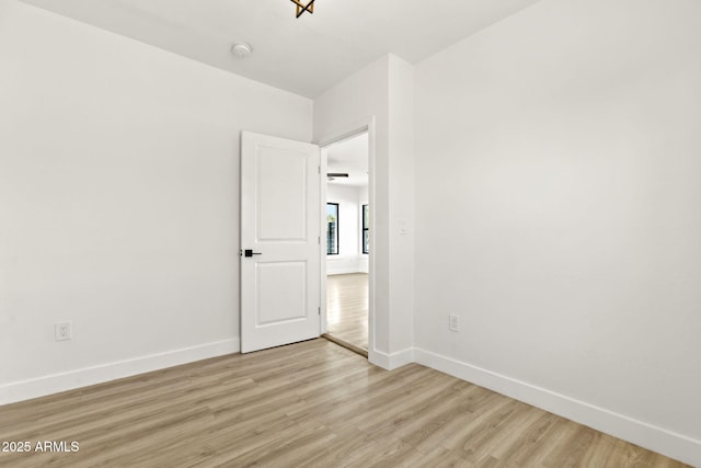 spare room with light wood-style flooring and baseboards