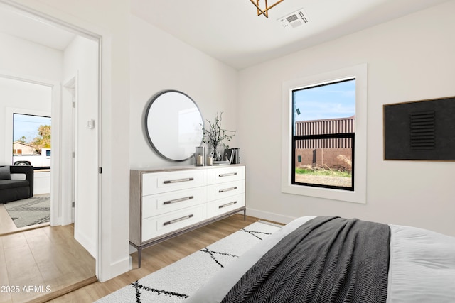 bedroom featuring baseboards, visible vents, and light wood-style floors