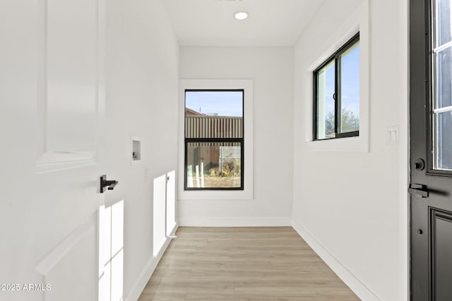 hall with light wood-type flooring, recessed lighting, plenty of natural light, and baseboards