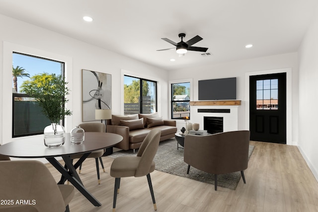 living room featuring light wood-style floors, recessed lighting, visible vents, and a fireplace