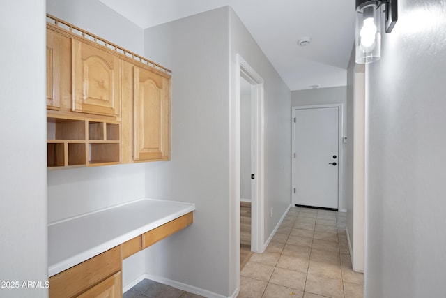 hall with baseboards and light tile patterned flooring