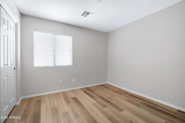 unfurnished room with visible vents, baseboards, and light wood-type flooring
