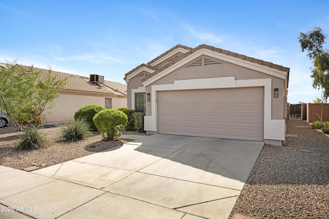 ranch-style home with fence, stucco siding, concrete driveway, an attached garage, and central air condition unit