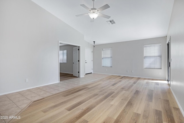 unfurnished living room with a healthy amount of sunlight, high vaulted ceiling, a ceiling fan, and visible vents