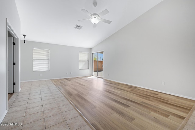 spare room featuring visible vents, baseboards, high vaulted ceiling, a ceiling fan, and light wood-style flooring
