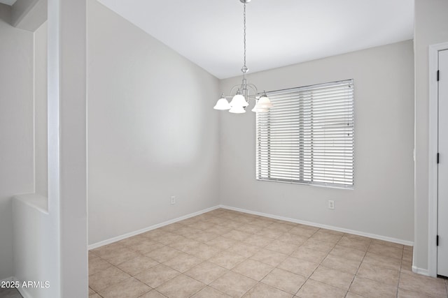 empty room with an inviting chandelier and baseboards