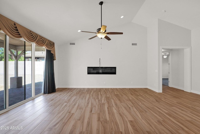 1336 E Belmont Ave, Phoenix, AZ 85020 - unfurnished living room featuring ceiling fan, a glass covered fireplace, light wood-type flooring, and high vaulted ceiling