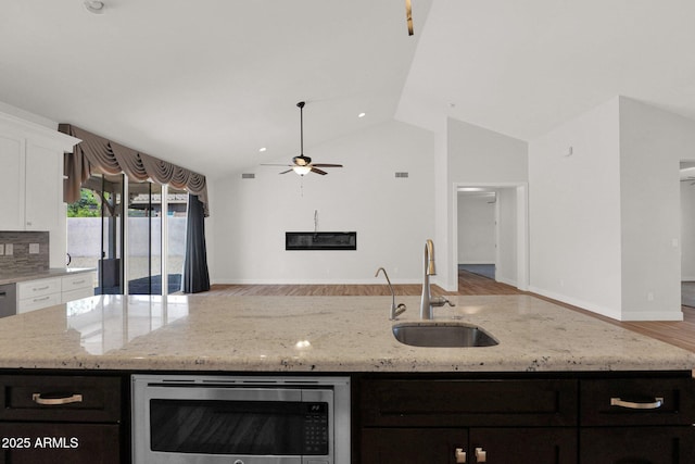 1336 E Belmont Ave, Phoenix, AZ 85020 - kitchen featuring stainless steel microwave, a center island with sink, white cabinetry, open floor plan, and a ceiling fan