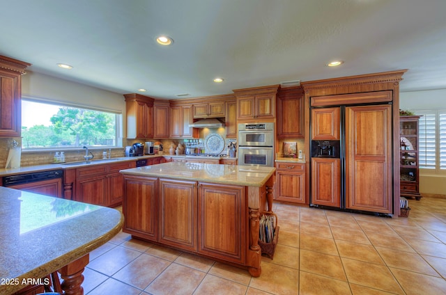 7155 E Oakmont Dr, Paradise Valley, AZ 85253 - kitchen featuring brown cabinets, backsplash, under cabinet range hood, and stainless steel appliances