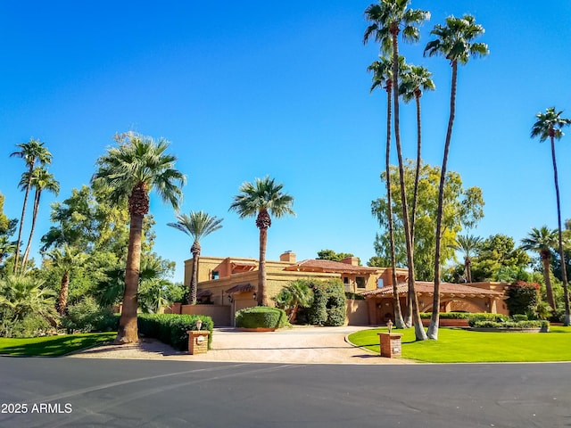 7155 E Oakmont Dr, Paradise Valley, AZ 85253 - mediterranean / spanish home featuring curved driveway, stucco siding, and a front yard