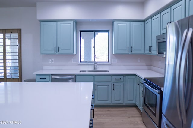 kitchen with light hardwood / wood-style flooring, stainless steel appliances, and sink