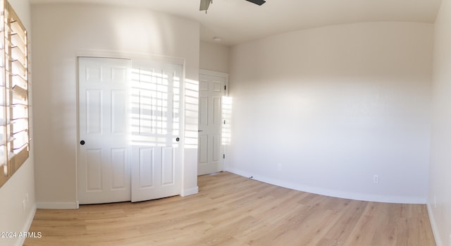 unfurnished bedroom featuring a closet, light hardwood / wood-style floors, and ceiling fan