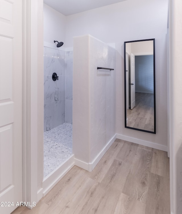 bathroom featuring a tile shower and hardwood / wood-style flooring