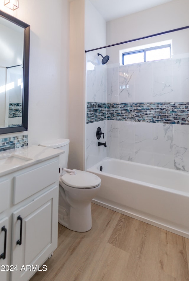 full bathroom with vanity, tiled shower / bath combo, wood-type flooring, and toilet