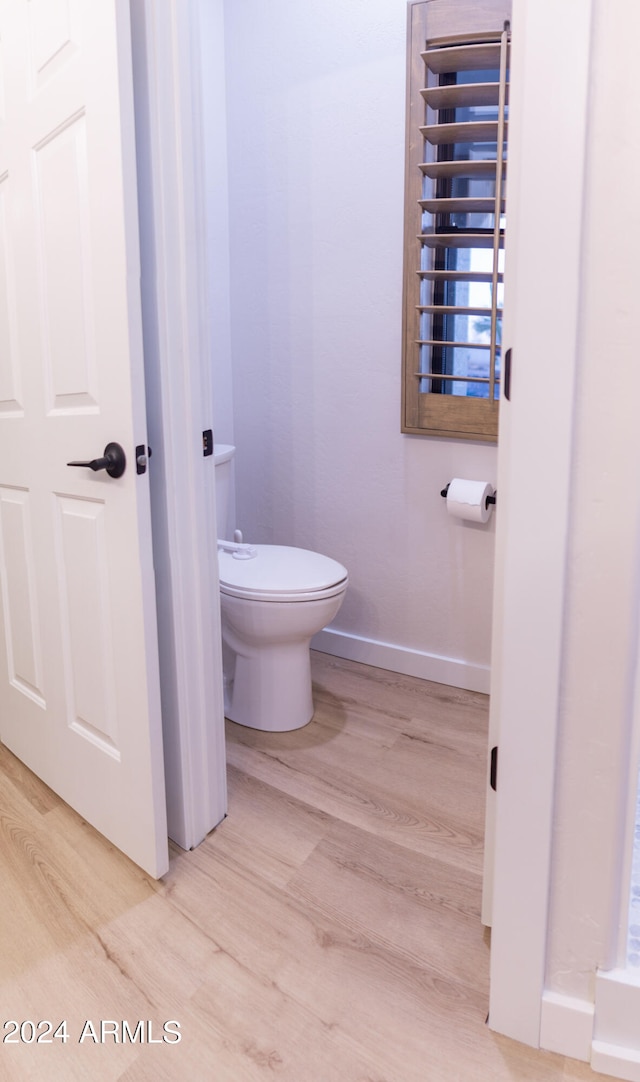 bathroom featuring toilet, radiator heating unit, and hardwood / wood-style flooring