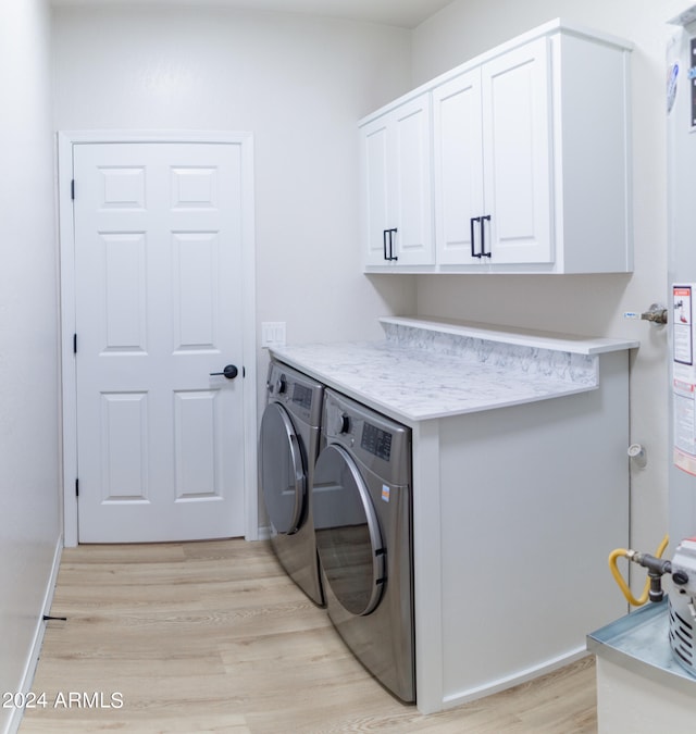 laundry area with cabinets, light hardwood / wood-style flooring, and separate washer and dryer