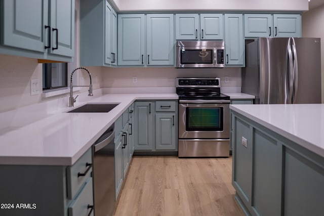 kitchen with sink, appliances with stainless steel finishes, and light wood-type flooring