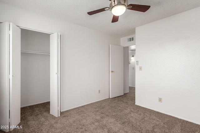 unfurnished bedroom with carpet, a textured ceiling, a closet, and ceiling fan