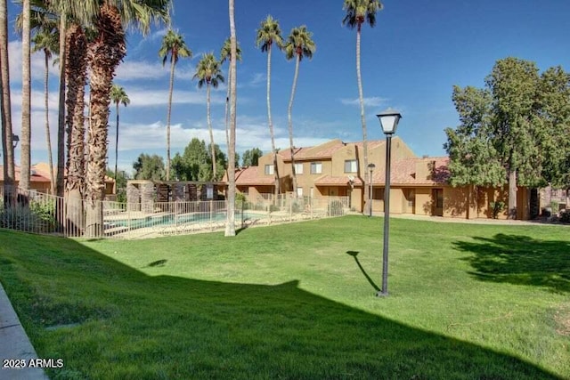 view of community featuring a pool and a lawn