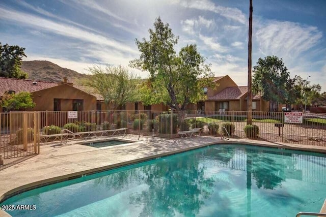 view of swimming pool with a mountain view, a hot tub, and a patio