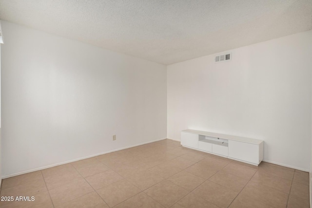 tiled spare room with a textured ceiling