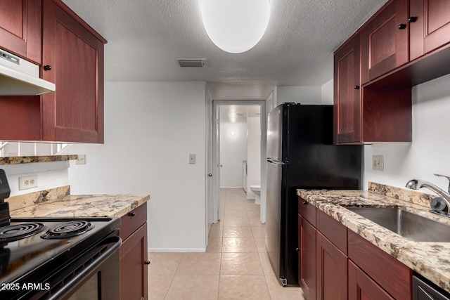 kitchen featuring black appliances, light stone counters, a textured ceiling, and sink