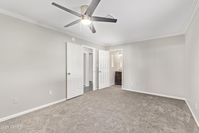 unfurnished bedroom with ceiling fan, carpet floors, crown molding, and ensuite bath