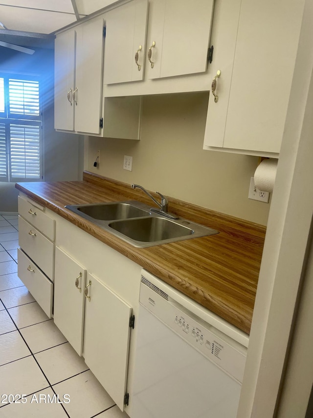 kitchen with dishwasher, sink, light tile patterned flooring, and white cabinets