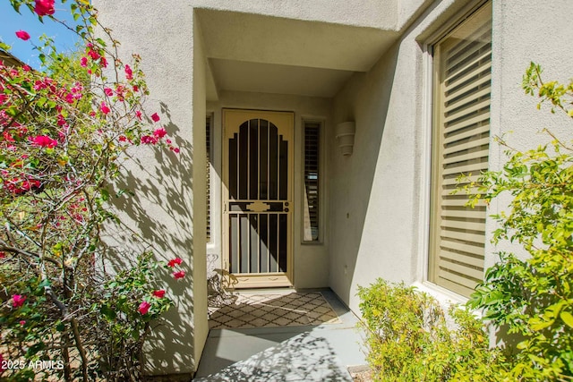 doorway to property featuring stucco siding