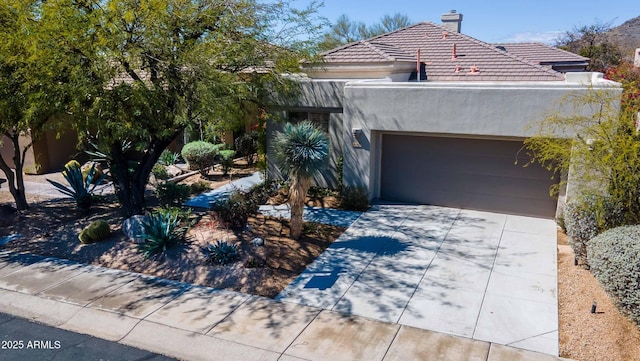 view of front of home with a garage, a tile roof, driveway, stucco siding, and a chimney