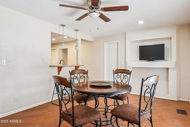 dining area with sink, light hardwood / wood-style flooring, and ceiling fan