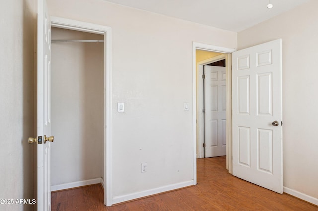 unfurnished bedroom featuring hardwood / wood-style flooring and a closet