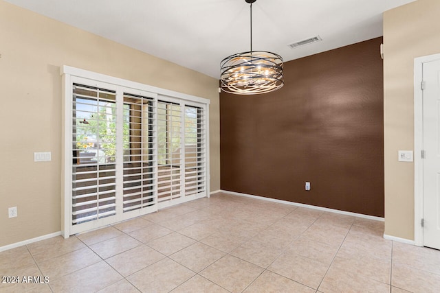 unfurnished room with light tile patterned flooring and a notable chandelier