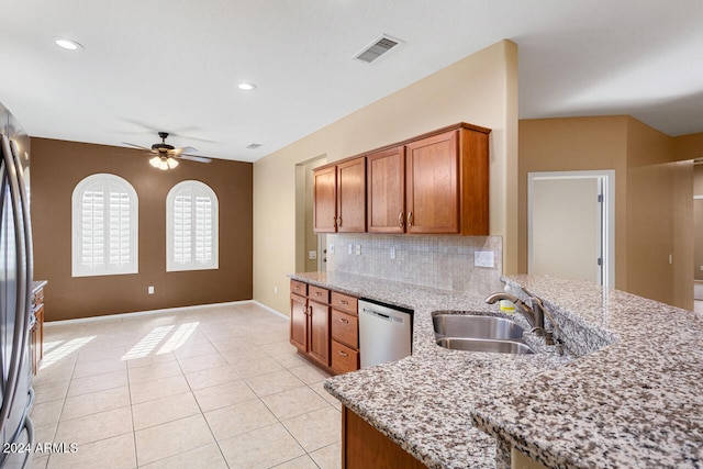 kitchen with ceiling fan, sink, stainless steel dishwasher, light stone countertops, and decorative backsplash