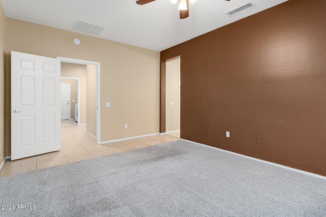 spare room featuring light carpet and ceiling fan